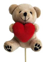 Teddy bear with a red heart on a stick against a white background